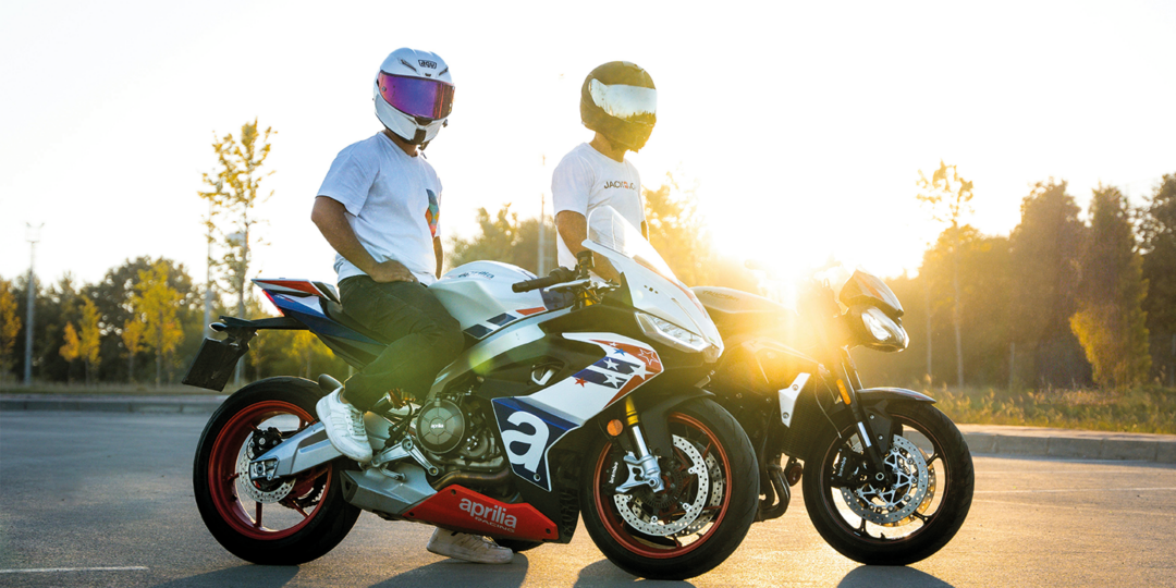 Twee motorrijders die in de zon staan